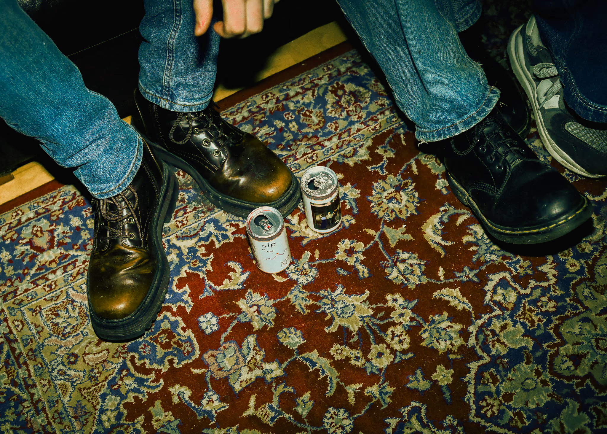 SIP cans on a patterned rug at a house party